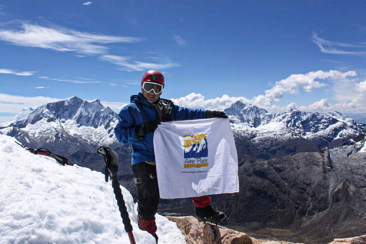 Montañista en la cima de una montaña nevada